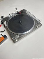 Top view of Panasonic SL-NS turntable with dust cover closed and MetroSound brush beside it