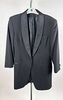 Front view of black tuxedo jacket on hanger showing satin shawl lapel and overall condition