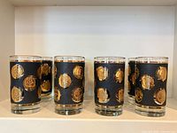 Front view showing six tumblers with gold coin motif