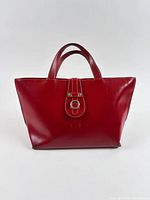 Front view of red Furla tote showing shape, handles, and closure tab