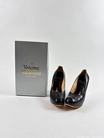 pair of black leather heels and box