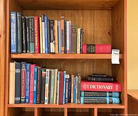 Two-shelf view of approximately fifty assorted books