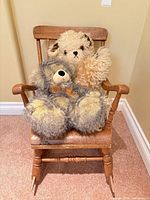 Wooden rocking chair holding two teddy bears