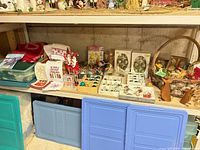 Full shelf showing variety of boxed ornaments, linens, elves and other décor