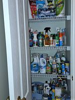 Closet shelves filled with assorted spray cleaners, aerosols, lubricants, leather care items