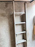 Top section of aluminum extension ladder showing rails and rungs