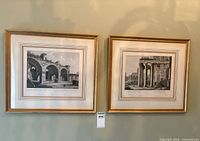 Both framed etchings side by side on wall