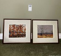 Both framed paintings side by side against wall