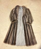 Full view of Jordan Livingston brown fur coat laid flat, lining visible