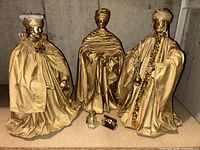 Three gold Wise Men figurines with glass bottle and small chest