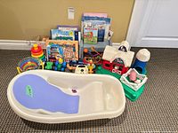 Lot overview with bath tub, toys and books lined up