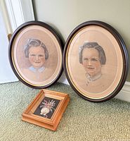 Group shot of two oval portraits and small floral painting
