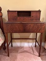 Front view of wooden secretary desk showing hutch and fold-down surface