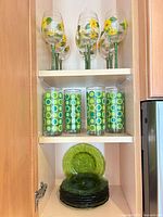 Wine glasses, highball glasses and plates arranged in cabinet