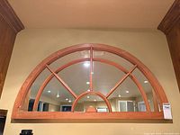 Front view of arched wood-framed mirror