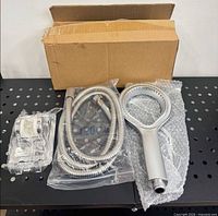 Shower head set with hose, mount and box on shelf