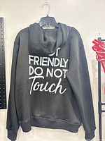 Back view showing full white text graphic on black hoodie