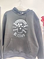 Full view of black hoodie on hanger showing front graphic and pocket