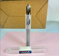 Drill bit standing in opened tube showing tip and flutes