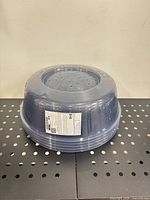 Stack of five transparent blue PRICKIG microwave covers showing vent holes and label