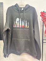 Front view of black hoodie displaying WILD forest graphic and pocket