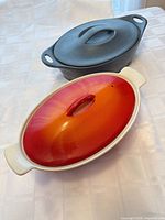 Front view of both covered dishes showing colors, shapes, lids