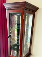 Full view of cabinet showing crown molding, glass panels and shelves