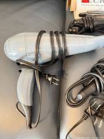 Gray hair dryer wrapped with cord