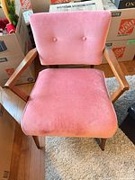 Front view showing full chair, upholstery, wooden arms and legs