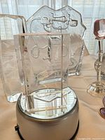 Front view showing rectangular crystal block on LED base, etched telephone plaque behind, glass rose, portion of perfume bottle