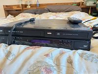 Front view of RCA DRC8335 combo unit with remote on top