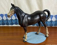 Right side view of cast iron horse coin bank showing paint, coin slot, stance