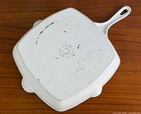 Underside of skillet showing white enamel and wear