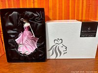 Figurine in satin-lined presentation box beside outer box