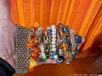 Hand holding assortment of bracelets showing variety and scale