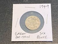 Coin in flip showing reverse crowned cipher and date