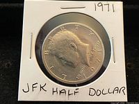 1971 Kennedy Half Dollar in cardboard flip, obverse visible