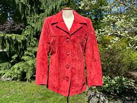 Front view of red suede jacket on mannequin showing buttons and collar
