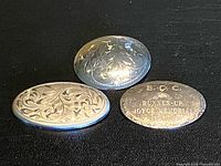 Three sterling silver oval discs grouped together showing front engraving