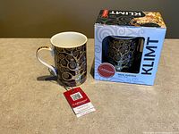 Mug with hangtag beside boxed mug