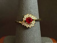 Front view showing ruby centre stone with clear halo