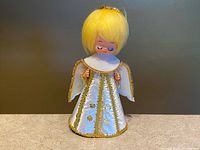 Front view of angel showing gown, wings, face, and hair