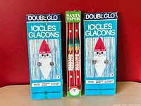 Front view of two Double Glo tinsel boxes and boxed Santa tapers