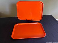 Both orange trays, one upright and one flat to show color and design