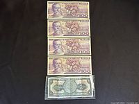 Four 100 Pesos notes stacked above one 1965 note in sleeve