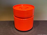 Full view of orange Heller ice bucket with lid on