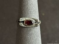 Front view showing red oval stone and accent stones on shoulders