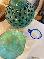 Top view of green pierced ceramic lantern, green bowl interior, clear creamer