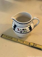 Hand-painted creamer pitcher with ruler for scale