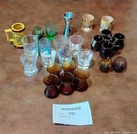 Group shot of all 23 shot glasses, mini mugs and jigger